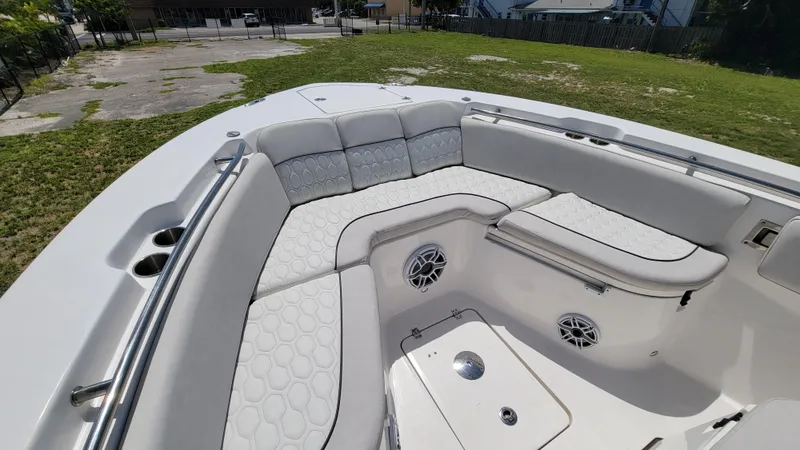Slide: The Image of 2024 Sea Fox 288 Commander boat interior with white cushioned seating and cup holders. - 16