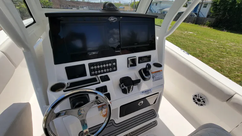 Slide: The Image of 2024 Sea Fox 288 Commander boat dashboard with dual screens and steering wheel. - 19