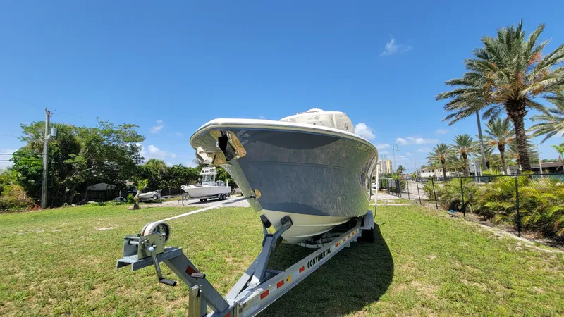 Slide: The Image of 2024 Sea Fox 288 Commander boat on trailer, parked on grassy area under clear blue sky. - 2