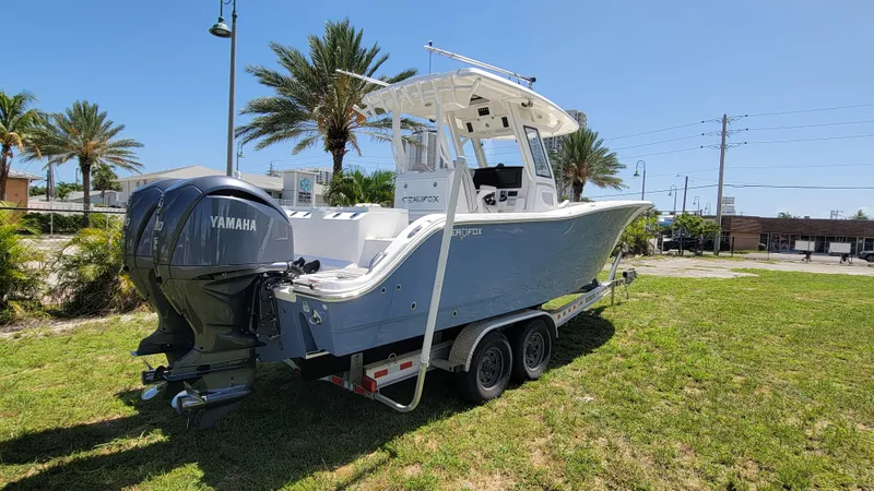 Slide: The Image of 2024 Sea Fox 288 Commander boat with Yamaha engines on a trailer, parked on grass. - 3