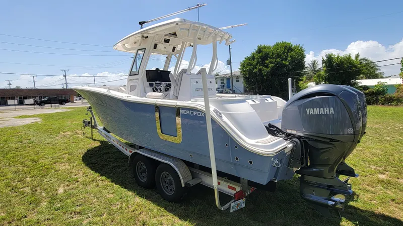 Slide: The Image of 2024 Sea Fox 288 Commander boat with Yamaha engine on a trailer, parked on grass. - 5