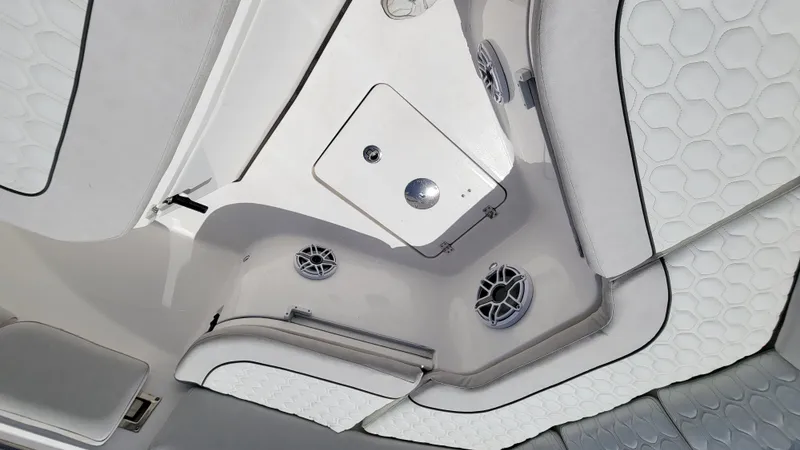 Slide: The Image of 2024 Sea Fox 288 Commander interior with white cushioned seating and built-in speakers. - 9