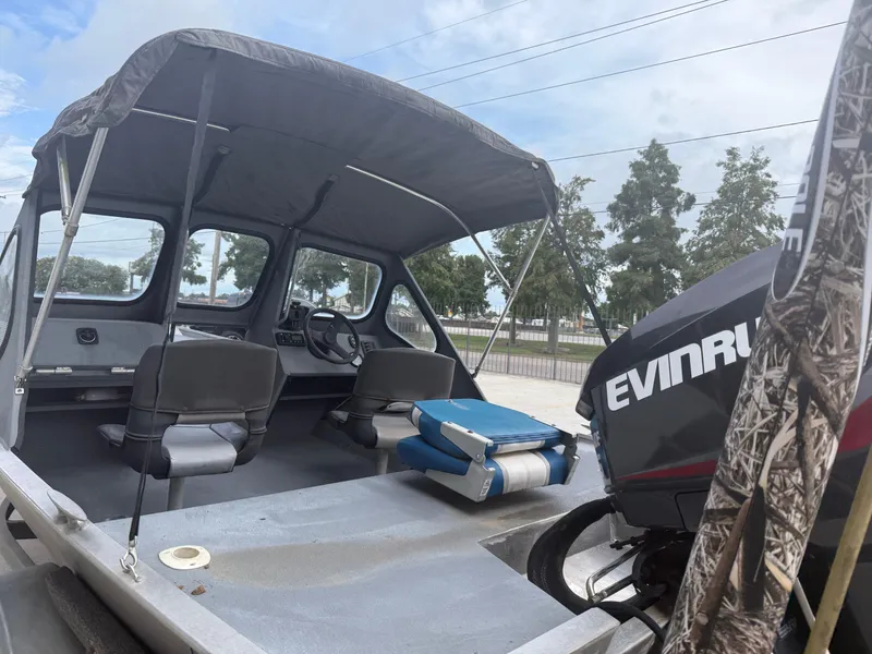 Slide: The Image of Interior of a 2015 Hanko 17 boat with Evinrude motor, featuring seating and canopy. - 24