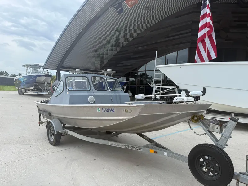 Slide: The Image of Small Hanko 17 boat on trailer, parked outside a modern building, American flag visible. - 4