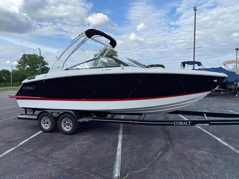 Slide: The Image of 2025 Cobalt R6 boat on trailer, parked outdoors under cloudy sky. - 2