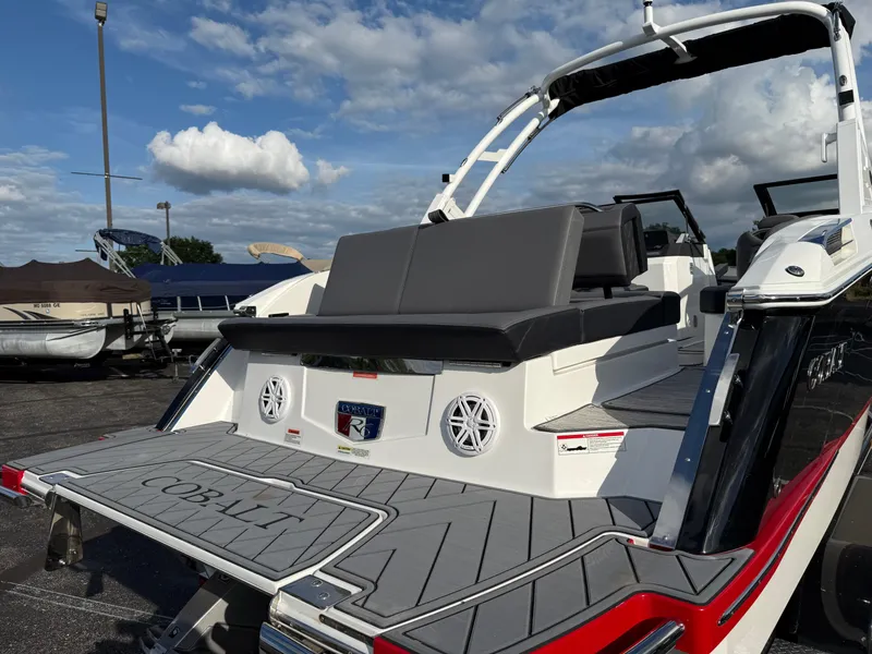 Slide: The Image of 2025 Cobalt R6 boat with sleek design and spacious seating, docked under a partly cloudy sky. - 5