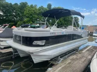 Slide: The Image of 2018 Avalon Catalina 2385QL pontoon boat docked, featuring a sleek design and canopy. - 0