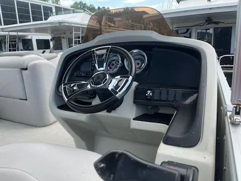 Slide: The Image of 2018 Avalon Catalina 2385QL boat dashboard with steering wheel and gauges. - 9