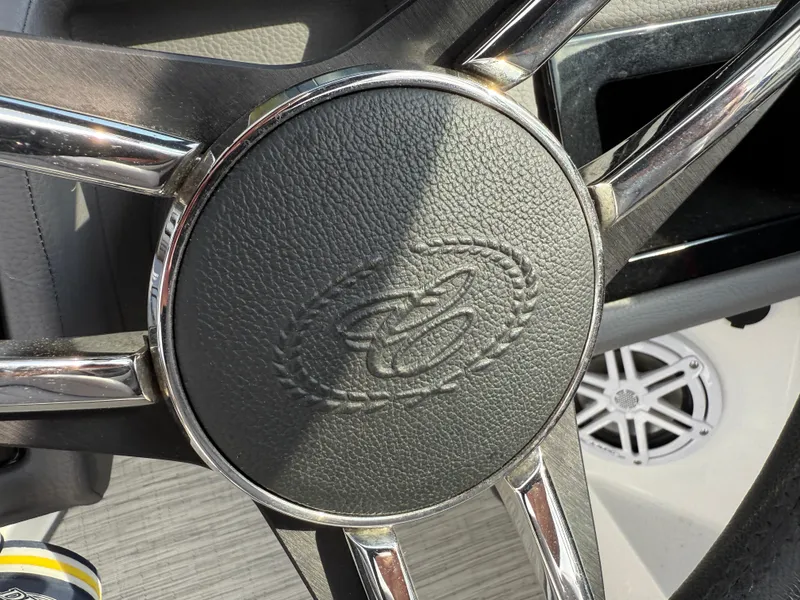 Slide: The Image of Steering wheel of a 2022 Cobalt R8 boat with chrome accents and embossed logo. - 32