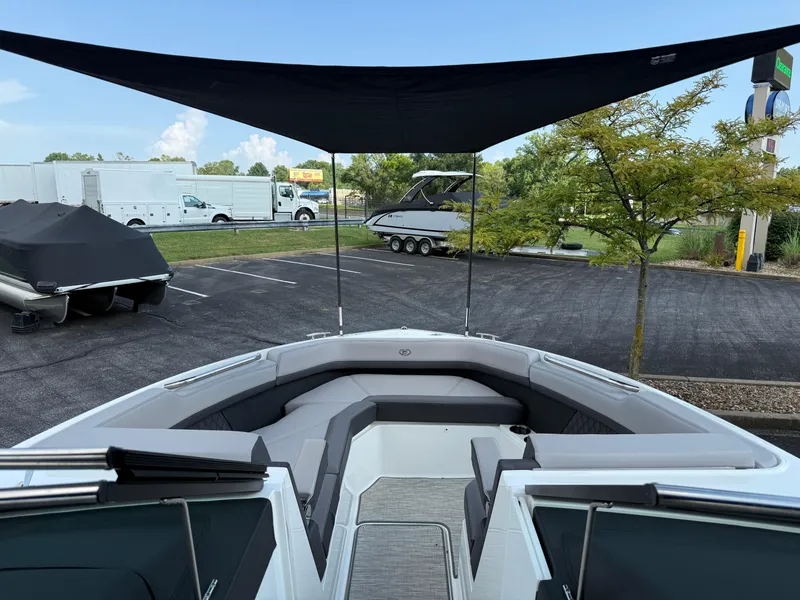 Slide: The Image of 2022 Cobalt R8 boat with canopy, parked outdoors near trailers and trees. - 39