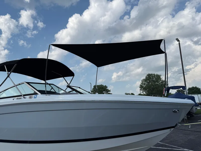 Slide: The Image of 2022 Cobalt R8 boat with black canopy under a partly cloudy sky. - 49