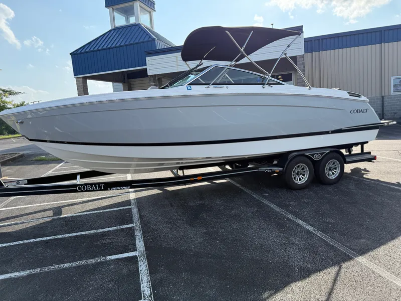 Slide: The Image of 2022 Cobalt R8 boat on trailer in parking lot, blue building in background. - 6
