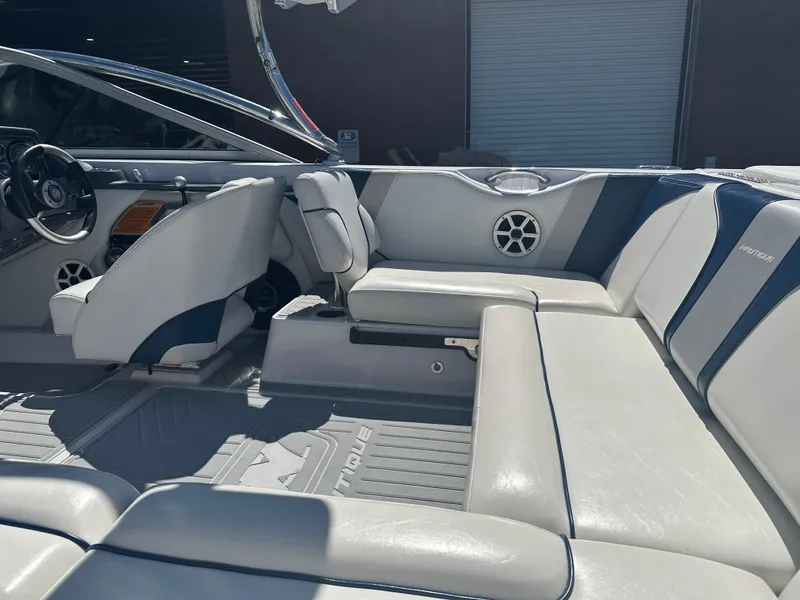 Slide: The Image of 2009 Nautique Super Air 210 interior with gray seating and steering wheel. - 10