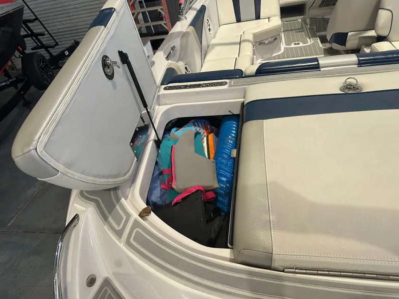 Slide: The Image of 2009 Nautique Super Air 210 boat interior with open storage compartment and gear. - 16