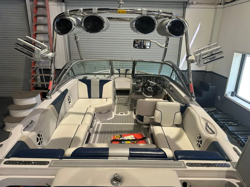 Slide: The Image of 2009 Nautique Super Air 210 boat interior with white and blue seating, speakers, and control panel. - 17