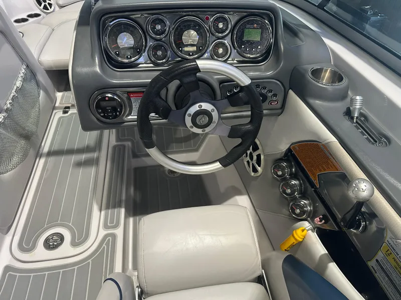 Slide: The Image of 2009 Nautique Super Air 210 boat dashboard with steering wheel and control panel. - 20