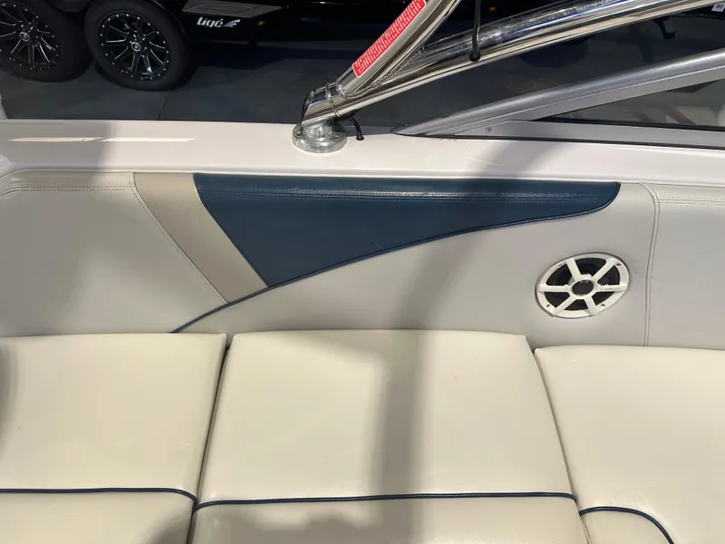 Slide: The Image of 2009 Nautique Super Air 210 interior with white and blue upholstery, featuring a speaker. - 22