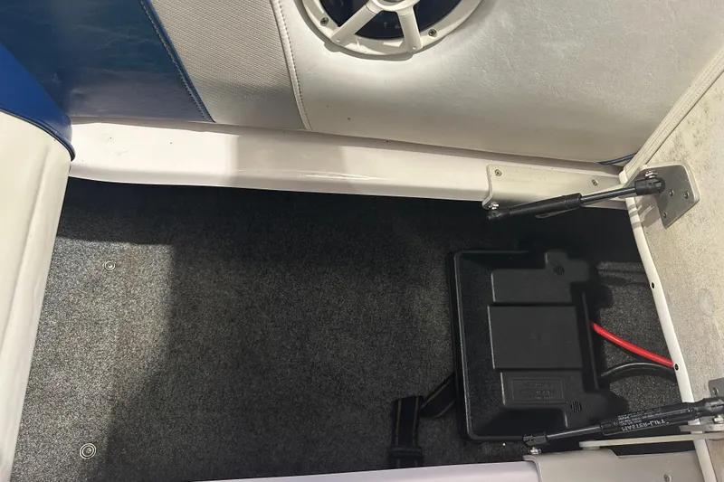 Slide: The Image of 2009 Nautique Super Air 210 interior storage compartment with speaker and battery box. - 27