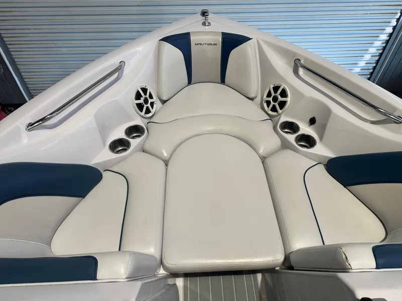 Slide: The Image of 2009 Nautique Super Air 210 boat interior with white and blue seating, cup holders, and speakers. - 31
