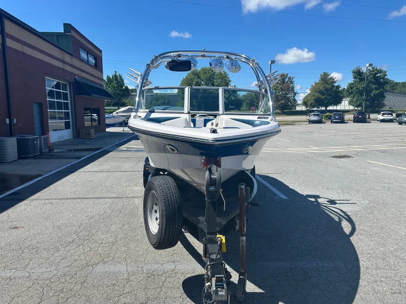 Slide: The Image of 2009 Nautique Super Air 210 boat on trailer in parking lot, sunny day. - 5