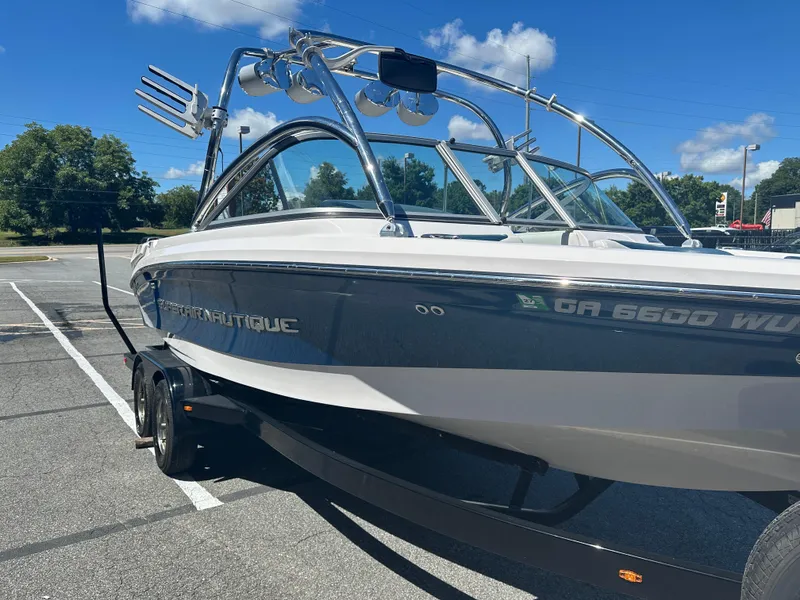 Slide: The Image of 2009 Nautique Super Air 210 boat on trailer under clear blue sky. - 6