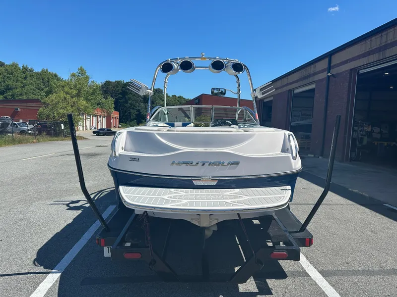 Slide: The Image of 2009 Nautique Super Air 210 boat on trailer, parked outside a warehouse. - 8