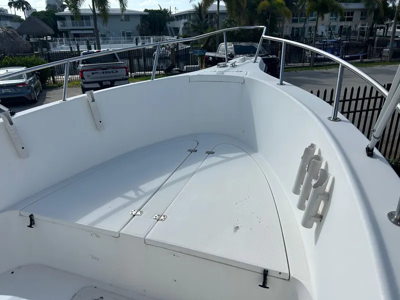 Slide: The Image of 1998 Cobia 224 CC boat deck with rod holders and storage compartments. - 12
