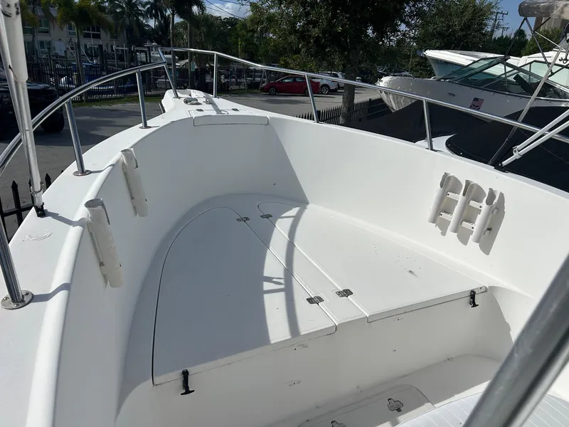 Slide: The Image of 1998 Cobia 224 CC boat interior, featuring spacious white deck and stainless steel railings. - 15