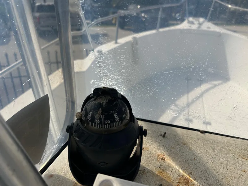 Slide: The Image of Compass on 1998 Cobia 224 CC boat, with clear protective cover and visible deck. - 9