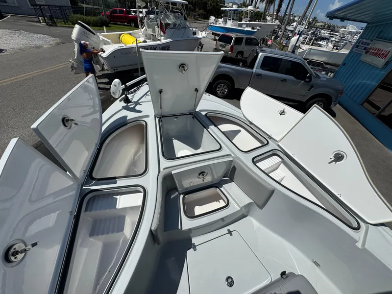 Slide: The Image of 2023 Blazer 2700 HYBRID BAY boat with open storage compartments at a marina. - 10