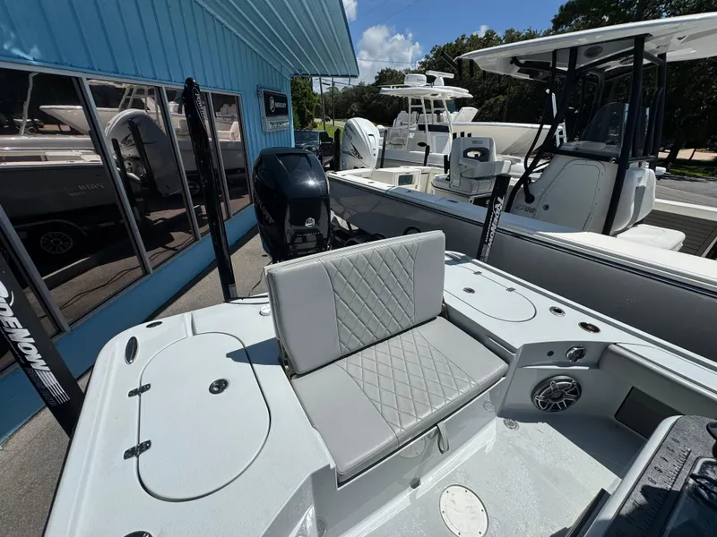 Slide: The Image of 2023 Blazer 2700 HYBRID BAY boat interior with seating and motor, displayed outdoors. - 12