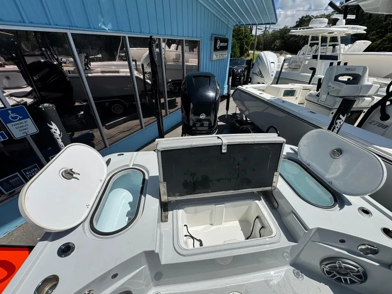 Slide: The Image of 2023 Blazer 2700 HYBRID BAY boat with open storage compartments at a dealership. - 13