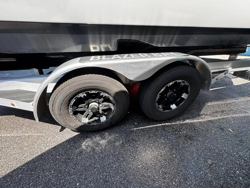 Slide: The Image of Trailer wheels of a 2023 Blazer 2700 HYBRID BAY boat on asphalt. - 23