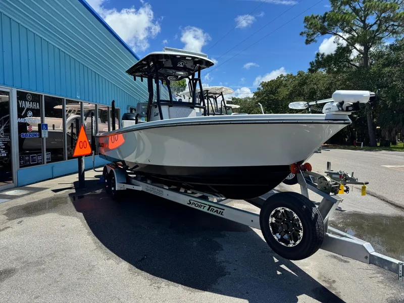 Slide: The Image of 2023 Blazer 2700 HYBRID BAY boats displayed outside a marine dealership under a blue sky. - 3