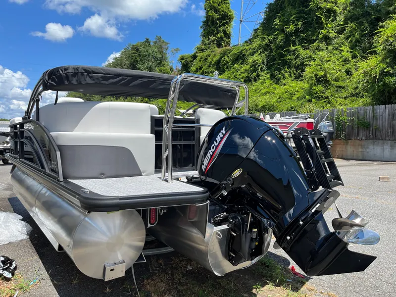 Slide: The Image of 2026 Harris Cruiser 210 pontoon boat with Mercury outboard motor, parked outdoors. - 31
