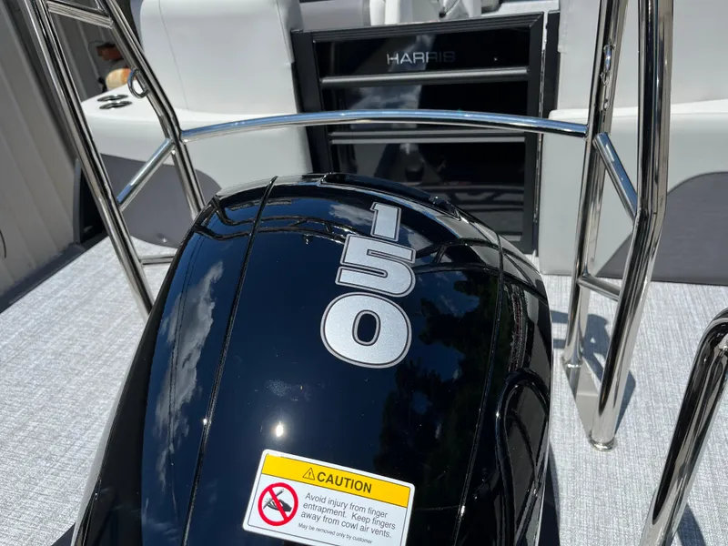 Slide: The Image of 2026 Harris Cruiser 210 boat with 150 horsepower engine, featuring sleek design and safety warning. - 32