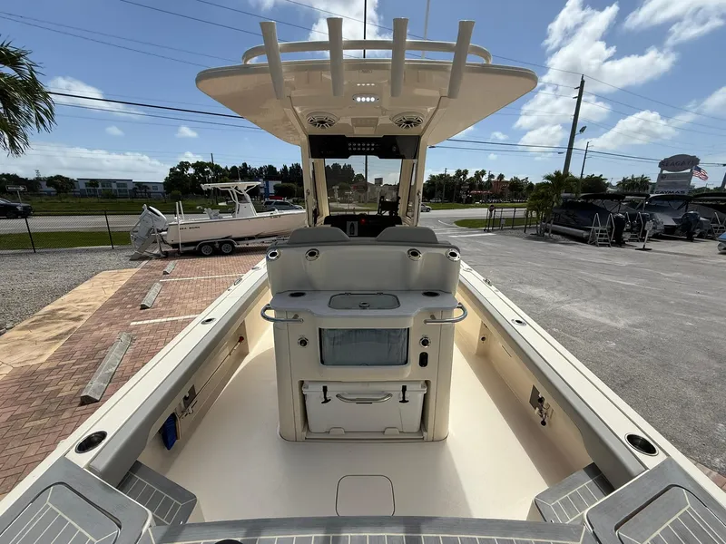 Slide: The Image of 2024 Scout 281 XSS boat interior with center console and seating, parked outdoors. - 10
