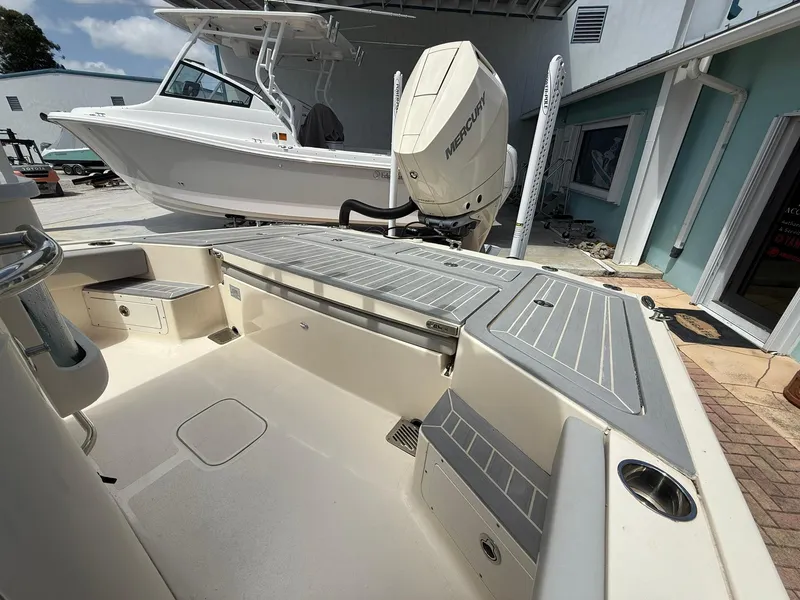 Slide: The Image of 2024 Scout 281 XSS boat with Mercury engine, docked outdoors. - 13