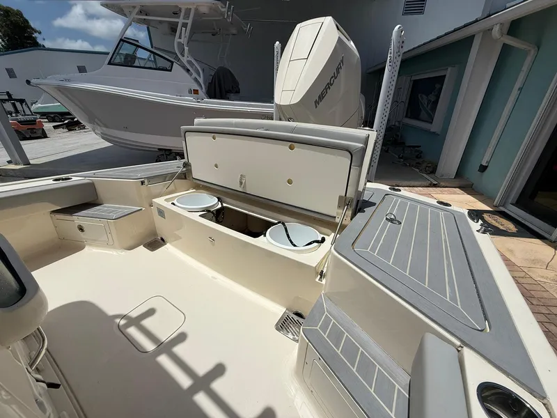 Slide: The Image of 2024 Scout 281 XSS boat interior with open storage compartments and Mercury engine. - 18