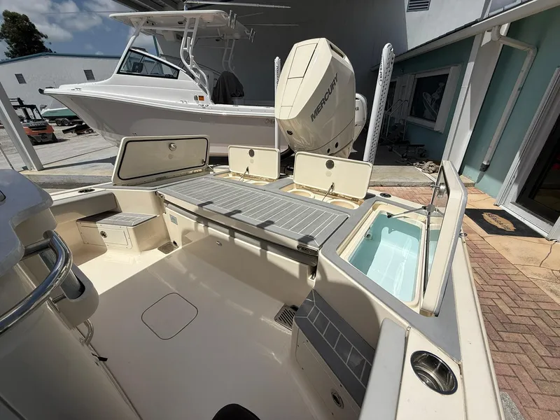 Slide: The Image of 2024 Scout 281 XSS boat interior with open storage compartments and Mercury engine. - 19