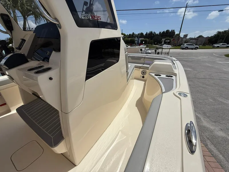 Slide: The Image of 2024 Scout 281 XSS boat interior with seating and console, parked outdoors. - 26