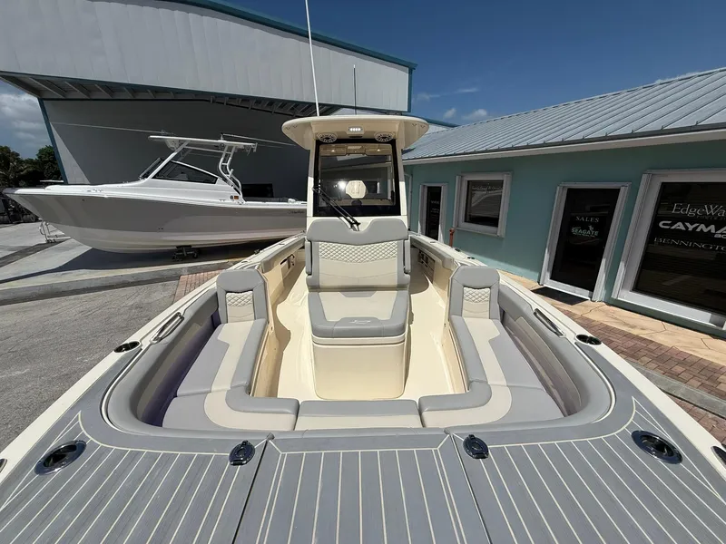 Slide: The Image of 2024 Scout 281 XSS boat with spacious seating, docked near a modern building. - 34