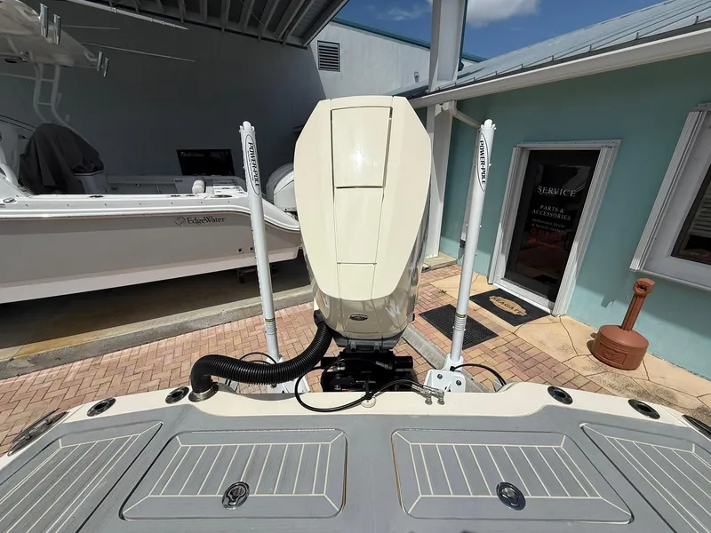 Slide: The Image of 2024 Scout 281 XSS boat engine and deck, parked near a service building. - 7