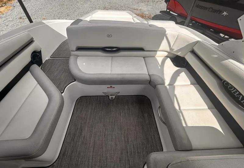 Slide: The Image of 2018 Cobalt CS23 boat interior with cushioned seating and carpeted flooring. - 16