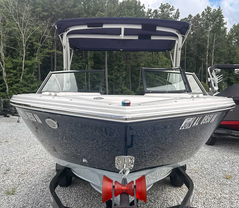 Slide: The Image of 2018 Cobalt CS23 boat on trailer, parked on gravel with forest background. - 3