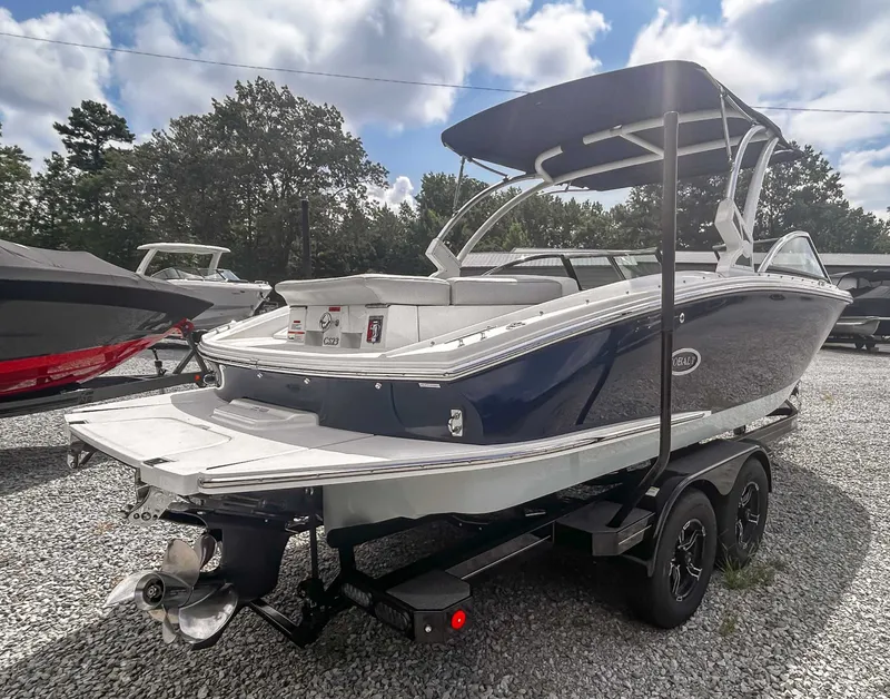 Slide: The Image of 2018 Cobalt CS23 boat on trailer, blue and white, parked on gravel lot. - 6