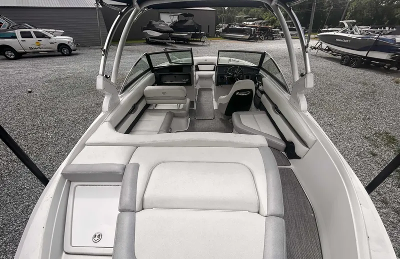 Slide: The Image of 2018 Cobalt CS23 boat interior with seating and steering wheel, parked outdoors. - 9