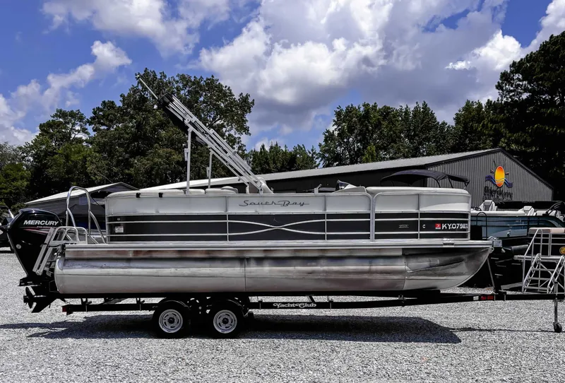 Slide: The Image of 2018 South Bay 200 Series S222RS 25 pontoon boat on trailer, parked outdoors. - 6