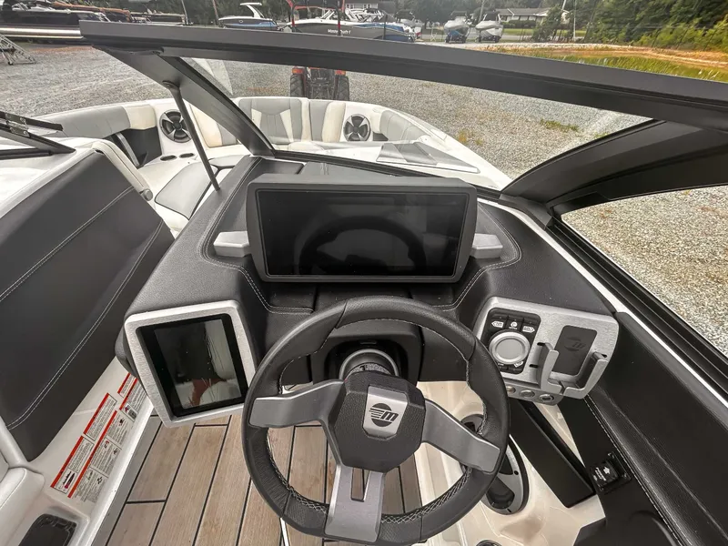 Slide: The Image of 2020 Malibu 23 MXZ boat dashboard with steering wheel and digital displays. - 15
