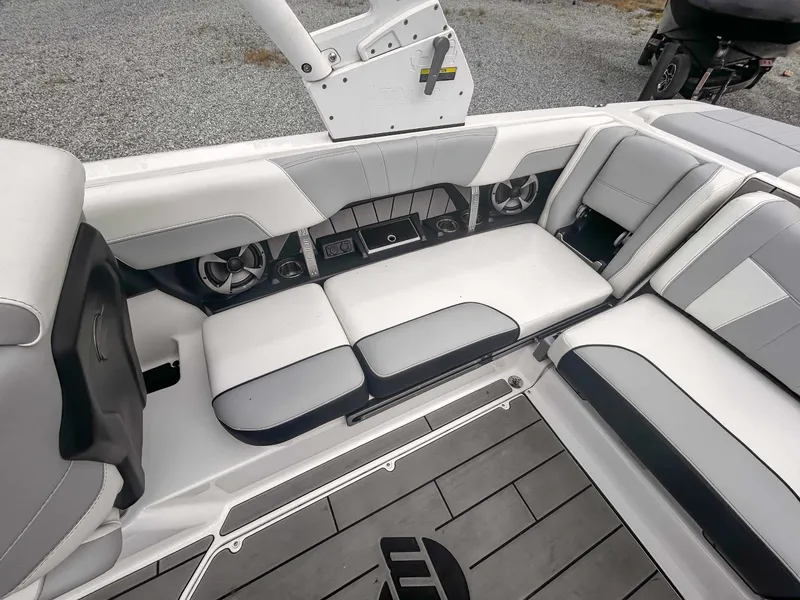 Slide: The Image of 2020 Malibu 23 MXZ boat interior with gray seating and speakers. - 16